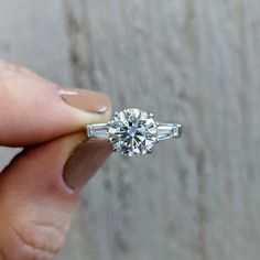 a person holding a diamond ring in their hand