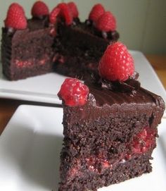 two pieces of chocolate cake with raspberries on top