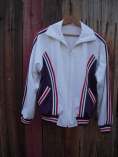 Sturdy terry lined track jacket with fantastic hand applique detail.  Classic track jacket style with full zip closure. Excellent vintage condition. Fully lined in stretch terry.  No size or fabric content tag.  Most likely poly or poly blend. Rib knit cuffs and hem.  All applique hand made and machine attached. Has been successfully machine washed.  Fits like a men's small. Laying flat measures: 23" armpit to armpit 15" bottom edge (hip) 25" neck edge near collar to hem Sporty Fleece Jacket With Ribbed Cuffs, Winter Track Jacket With Contrast Stripes And Long Sleeves, Fitted Cotton Track Jacket For Sports, Sports Fleece Track Jacket With Zipper, Sports Fleece Track Jacket With Zipper Closure, Fall Sports Track Jacket With Fleece Lining, Fleece Track Jacket With Zipper For Sports, Fleece Track Jacket With Zipper Closure For Sports, Fitted Winter Track Jacket With Ribbed Cuffs