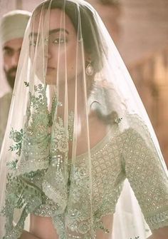 a woman in a wedding dress and veil is looking at the camera with an intense look on her face