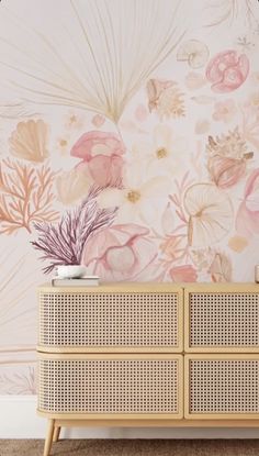 a dresser with flowers painted on it in front of a pink wallpapered background