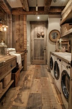 a washer and dryer in a room with wood flooring on the walls