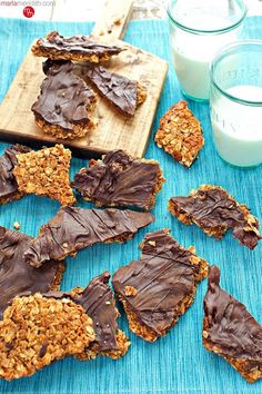 chocolate and oatmeal cookies on a blue mat next to a glass of milk