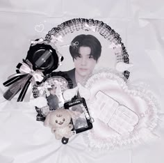 an image of a person surrounded by other items on a white cloth covered tablecloth