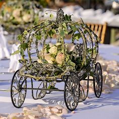 a carriage with flowers in it sitting on a table