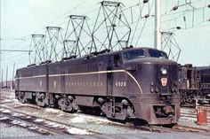 an electric train on the tracks with power lines in the background