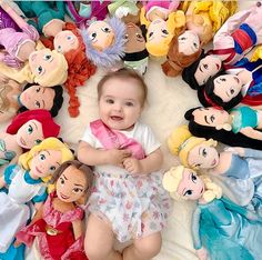 there is a baby surrounded by many dolls