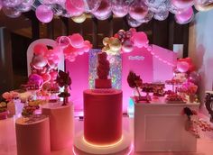 pink and gold birthday party with balloons, cake and candy bar in the center area