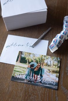 an open photo album sitting on top of a wooden table next to two rolls of tape