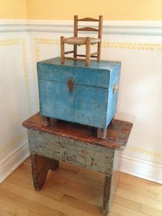 an old wooden chair sitting on top of a blue chest