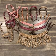 a collection of different types of belts and whippets on the floor in front of a wooden wall