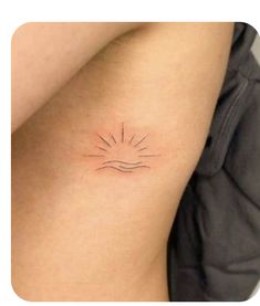 a small sun tattoo on the back of a woman's left arm and shoulder