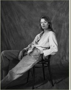 a black and white photo of a woman sitting on a chair