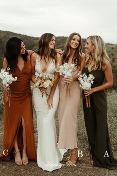 four bridesmaids standing together in the desert with their bouquets smiling at each other