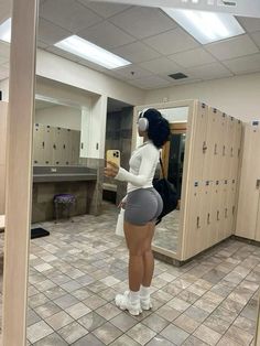 a woman is taking a selfie in the locker room