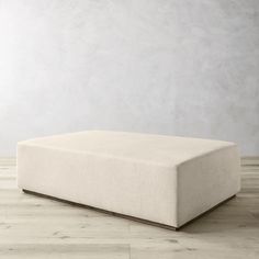 a white ottoman sitting on top of a wooden floor