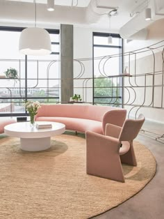 a living room filled with lots of furniture next to large windows and floor to ceiling windows