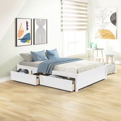 a white bed with two drawers underneath it in a room that has hardwood floors and walls