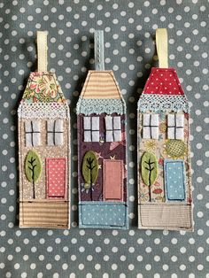 three small houses made out of fabric on top of a polka dot cloth tablecloth