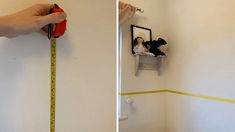 someone is measuring the wall with a tape measure and there are two pictures hanging on the wall