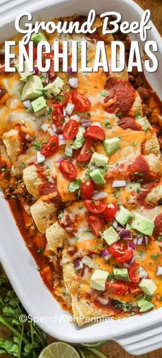 a casserole dish filled with ground beef enchiladas and garnished with avocado