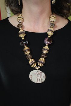 "Gorgeous pendant necklace in mostly natural color with accents of dark brown and purple. Agate pendant contains pinkish-purple hues. There are 2 purple shell beads and 4 coconut wood \"tortoise\" beads in this arrangement.  Necklace measures 25\" from clasp to clasp. This is a one of a kind item. Necklace cannot be duplicated." Bohemian Brown Shell Necklace With Wooden Beads, Brown Amulet Necklaces With Large Beads, Brown Wooden Beads Pendant Necklace, Brown Wooden Beads Amulet Necklace, Coconut Wood, Rose Violette, Pinkish Purple, Purple Agate, Purple Hues