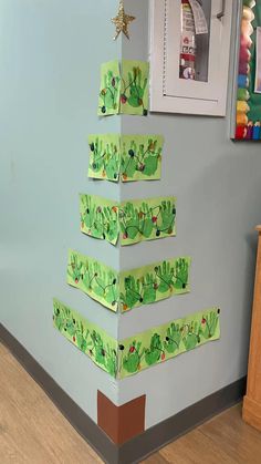 a christmas tree made out of construction paper on the side of a wall in an office