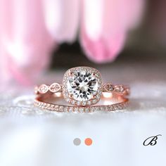 a close up view of a diamond ring on a table with flowers in the background