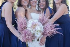 four bridesmaids pose with their bouquets in front of the photographer's face