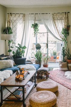 a living room filled with lots of furniture and plants on the windows sills