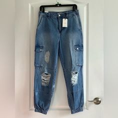 Nwt Forever 21 Denim Jogger Cargo Pants Size 28 Color Blue Fitted Waist/ Relaxed Hips Distressed Look 100% Cotton Machine Washable A Pair Of Stonewashed Jeans Featuring A Distressed Design, Ankle Cut, Jogger Hem, Cargo Pockets With A Snap-Button Flap Closures, Four Pocket Construction, And A Zip Fly With A Button Closure. Smoke Free Home Casual Ripped Straight Leg Cargo Pants, Mid-rise Ripped Cargo Jeans In Medium Wash, Casual Ripped Denim Cargo Pants, Ripped Denim Utility Bottoms, Medium Wash Denim Cargo Pants With Tapered Leg, Tapered Leg Medium Wash Denim Cargo Pants, Medium Wash Tapered Denim Cargo Pants, Trendy Medium Wash Tapered Leg Cargo Jeans, Forever 21 High Waist Bottoms With Pockets