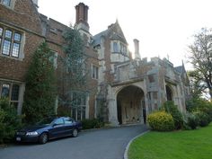 a car parked in front of a large brick building with an arched doorway and entrance