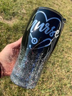 a hand holding a blue and silver cup with the word love on it in white writing