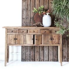 a wooden table with drawers and a potted plant on top