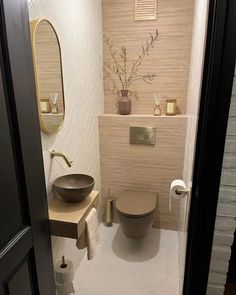 a bathroom with a toilet, sink and mirror on the wall next to each other