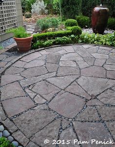 Pieced flagstone patio "mortared" with Mexican beach pebbles. Click through for more. Flower power out front; in back a serene, green garden | Digging Patio Flagstone, Backyard Pavers, Pavers Patio, Stone Patio Designs, Diy Patio Pavers, Pavers Backyard, Patio Pavers Design, Fire Pit Landscaping, Stone Patio