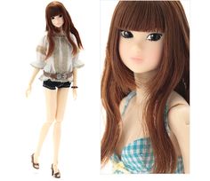 a doll with long brown hair wearing shorts and a blouse on top of her head