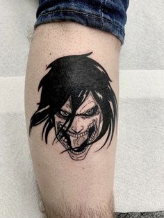 a man's leg with a tattoo on it that has an evil face and teeth