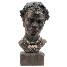 a statue of a woman with necklaces on it's neck and head is shown against a white background