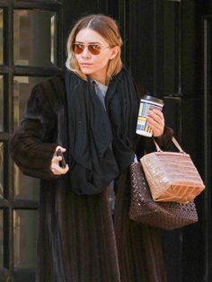 the woman is carrying her purse and coffee