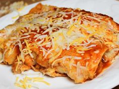 a white plate topped with lasagna covered in grated cheese on top of it