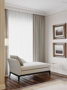 a white chaise lounge chair sitting in front of a window with drapes on it