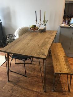 a wooden table with two benches next to it on a hard wood floor in a kitchen