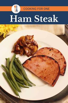 the cover of cooking for one ham steak with green beans and onions on a white plate