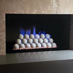 an electric fireplace with blue flames and balls on the bottom, surrounded by other white balls