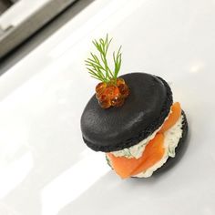 there is a small piece of food on top of a white plate with a garnish