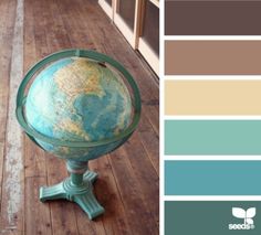 a globe sitting on top of a wooden floor in front of a window with color swatches