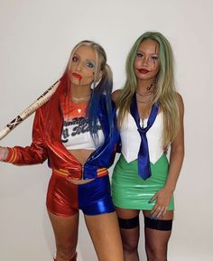 two women dressed up in costumes posing for a photo with baseball bats on their heads