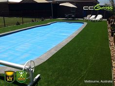 an empty swimming pool surrounded by artificial grass