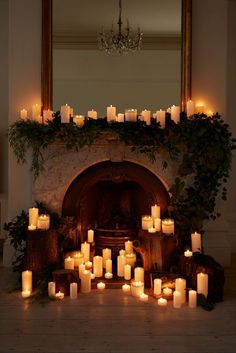 a fireplace with many lit candles in front of it